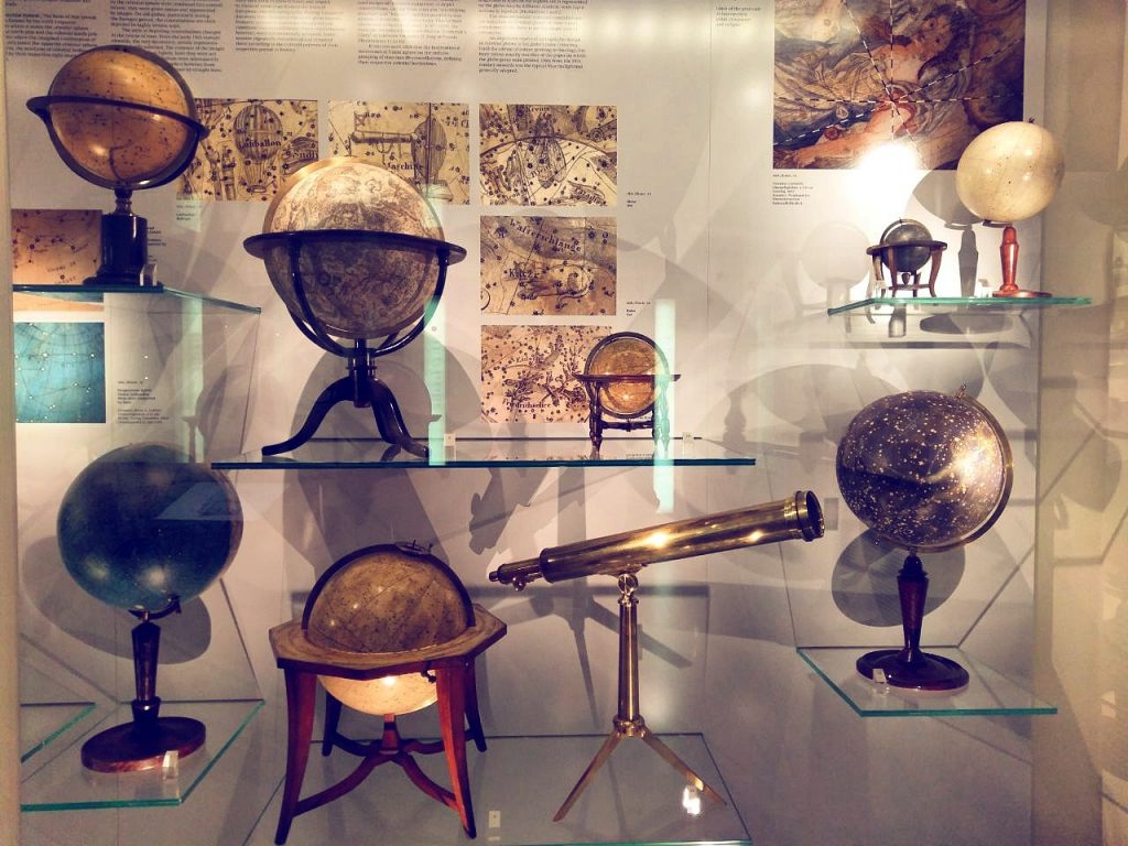 Verschiedene Globen mit goldenem Fernrohr